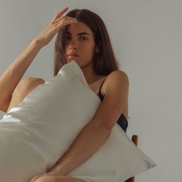 Model holding white Drowsy silk pillowcase