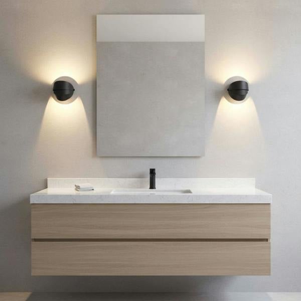 black vanity sconce light mounted either side of a mirror in a modern bathroom 