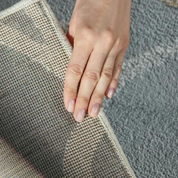 Hand touching a textured surface with a neutral color palette