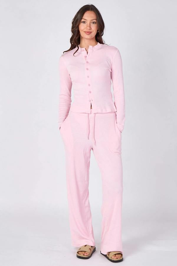 Woman wearing a pink pajama set on a white background