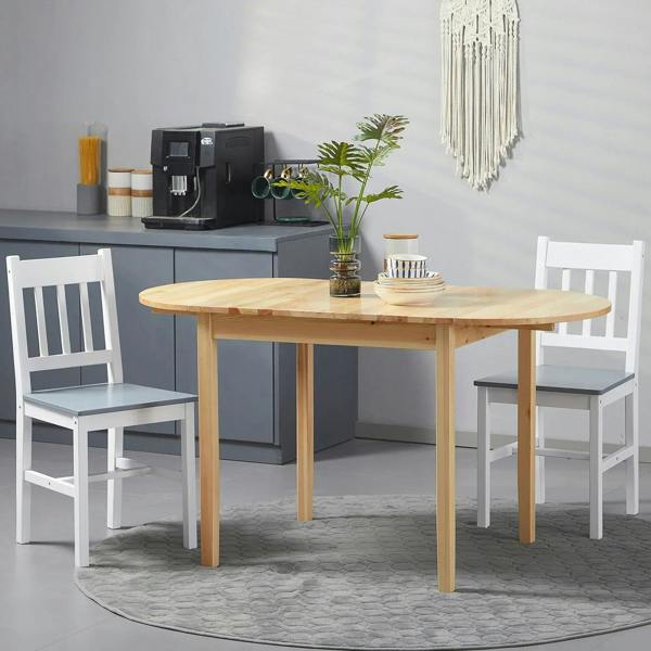 Natural wood drop-leaf dining table with two chairs in a compact kitchen dining setup