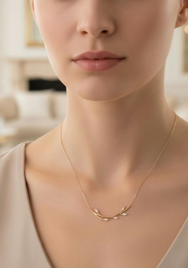 Close-up of a person wearing a delicate gold necklace with a blurred background