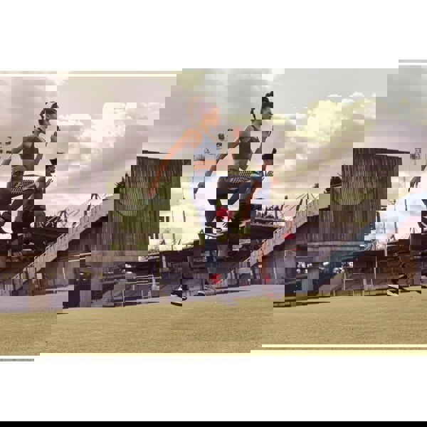 Man and woman working out on a field wearing Reebok Flexlock Ankle Weights 0.5kg