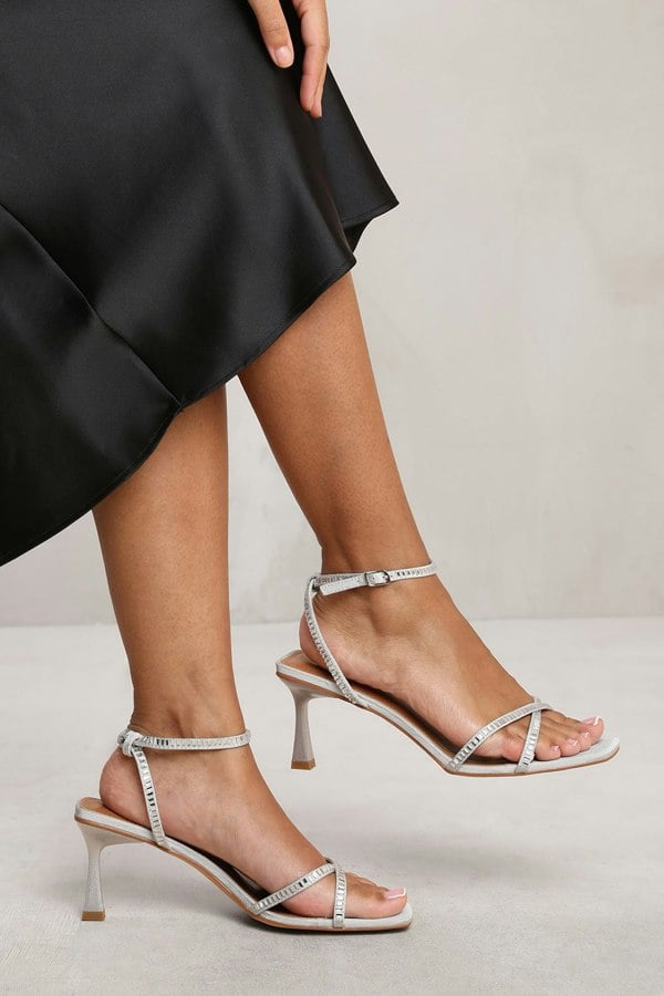 Where's That From Blair Wide Fit Square Toe Low Block Heel With Diamante Cross Over Strap Detail in Silver Satin