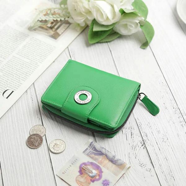 Green wallet on a wooden surface with coins and a card