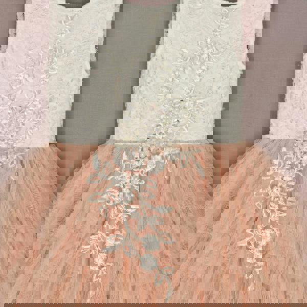 White lace top and peach tulle skirt dress with floral embroidery on a plain background