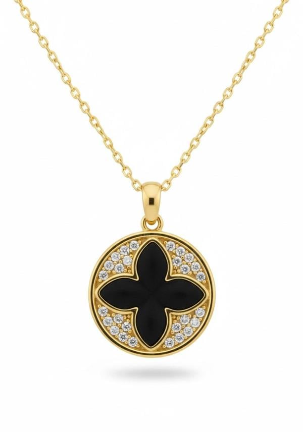 Gold necklace with a black clover pendant and diamond accents on a white background