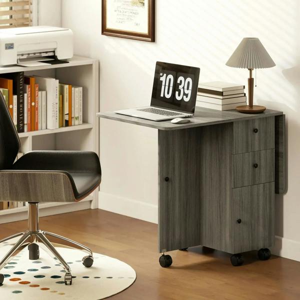 Grey drop-leaf dining table with side drawers and wheels in a home office