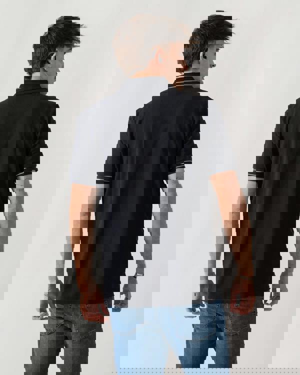 back shot of a model wearing a BOSS Green PL_Member Mens Short Sleeve Polo Shirt in Dark Blue 402