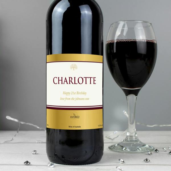 Personalised Red Wine bottle with a custom label next to a filled red wine glass.