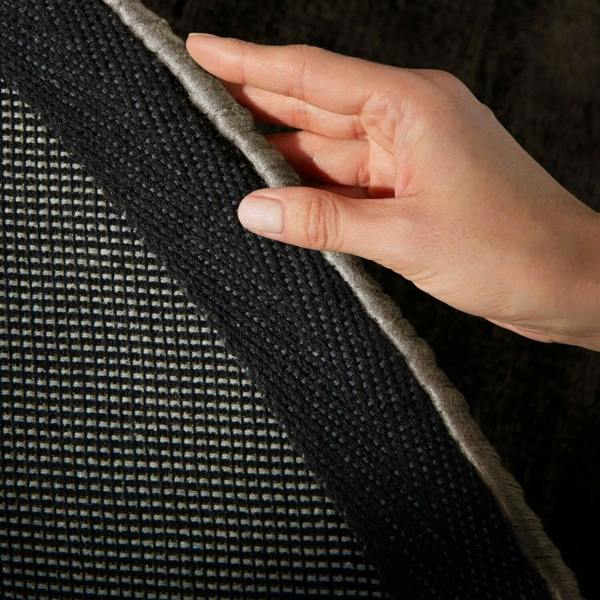 Hand touching a textured black surface