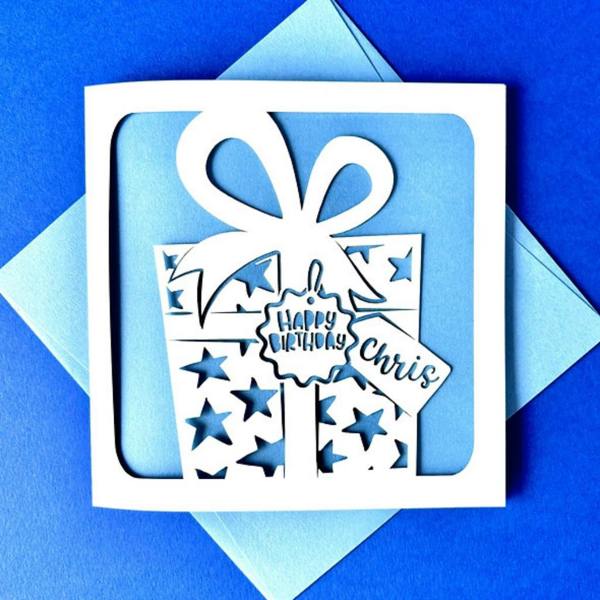Personalised papercut birthday card with wrapped gift box and blue insert customised with name Chris