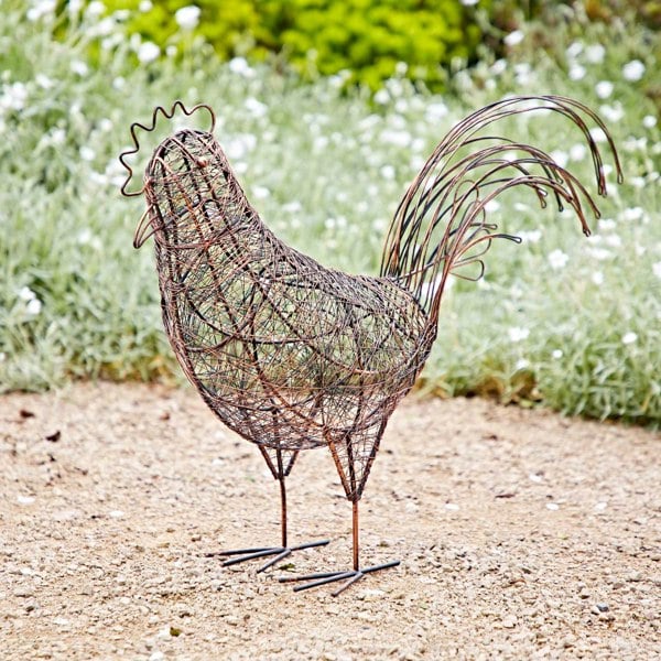 a Metal Hen Garden Decoration standing on a gravel path.