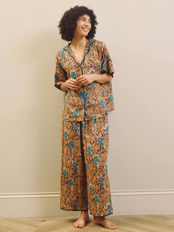 Woman wearing a patterned pyjama set against a plain background