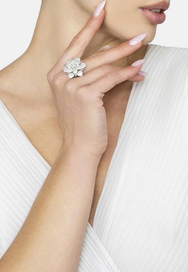 Woman wearing a silver floral ring on a white background