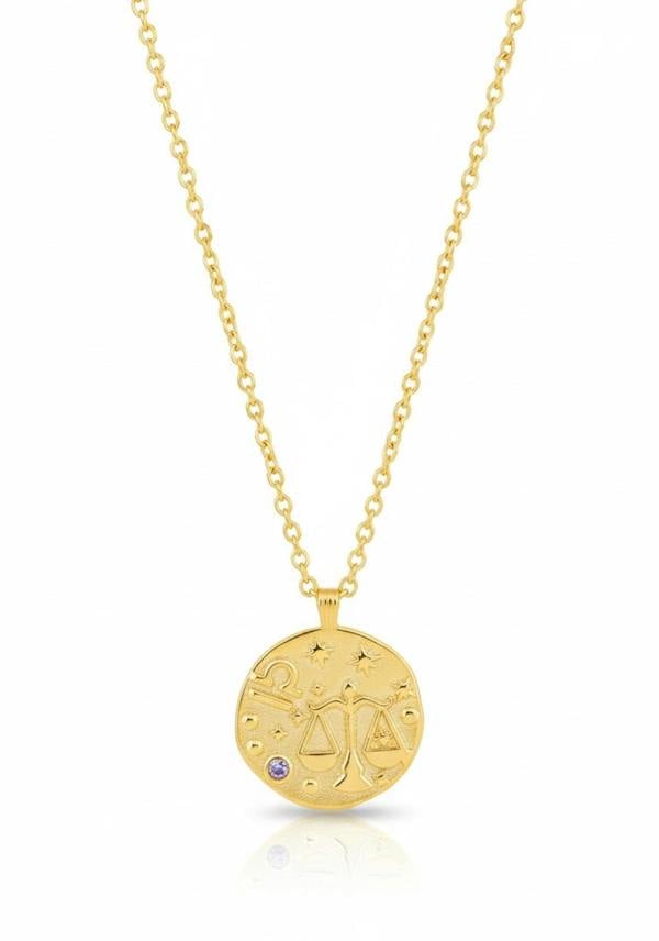 Gold necklace with Libra zodiac pendant on a white background