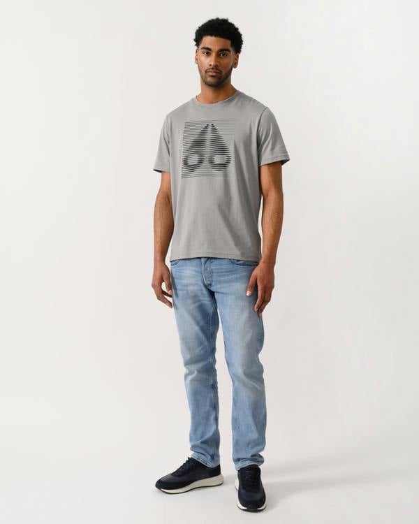 full length shot of a model wearing a Moose Knuckles Raydaze Mens T-Shirt in Industry 1892 colourway