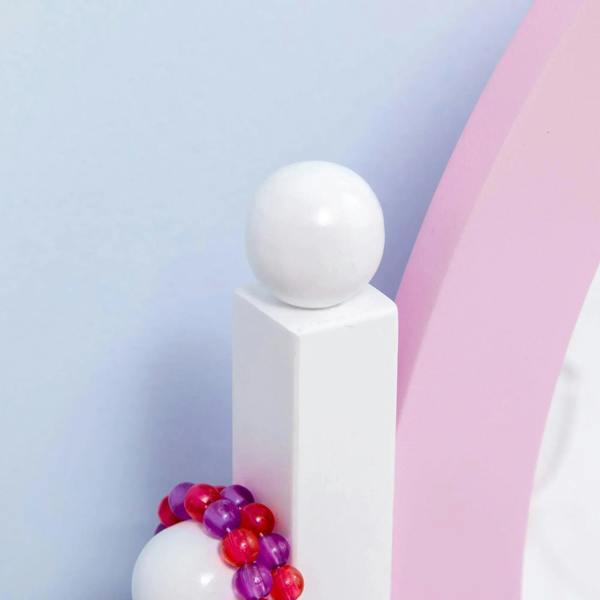 White round knob and pink side panel with colorful hair accessories on kids vanity set
