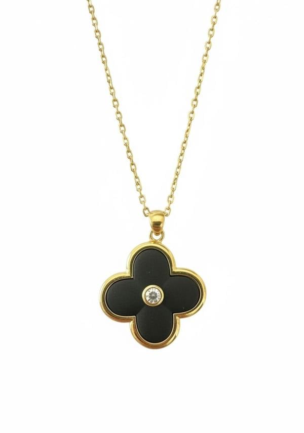 Black clover-shaped pendant with a gold chain on a white background