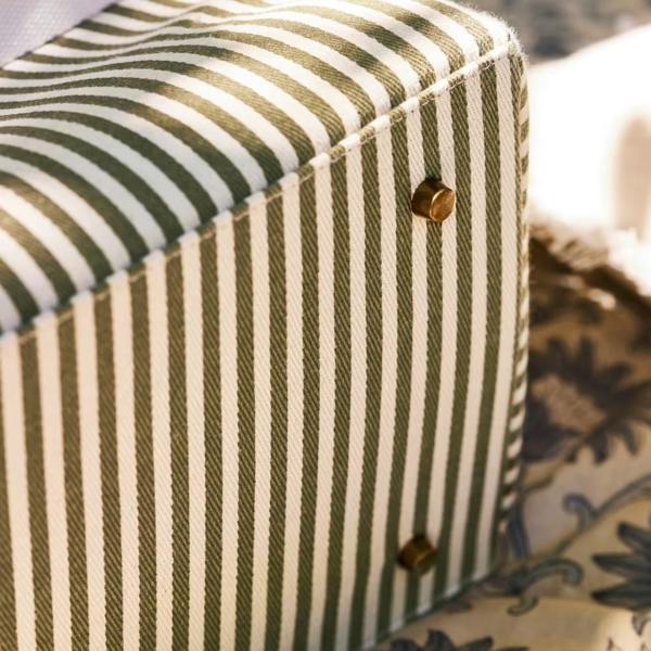 Antique brass-style studs on the base of the striped canvas bag.