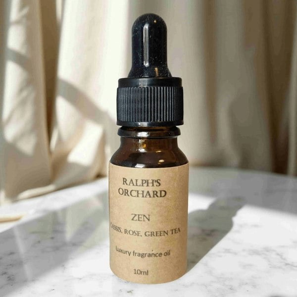 Bottle of Ralph's Orchard Zen fragrance oil on a marble surface with a neutral background