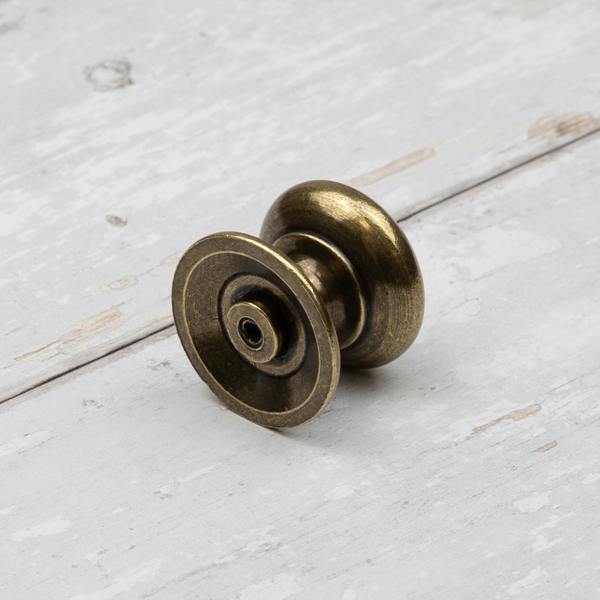 An antique brass round curved classic traditional knob