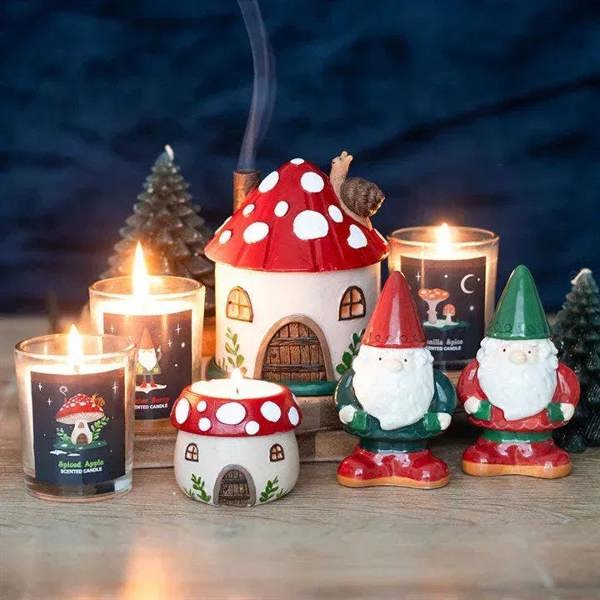 Mushroom house resin tealight holder with red cap and cream facade, lit candles around
