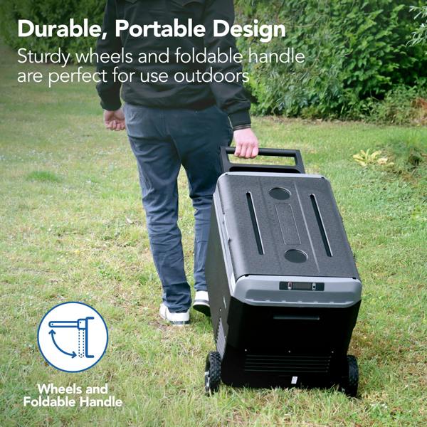A person pulls the Igenix 50L Portable Fridge Freezer, Black, with sturdy wheels and a foldable handle across grass. Text: Durable, portable design—ideal for outdoor use.