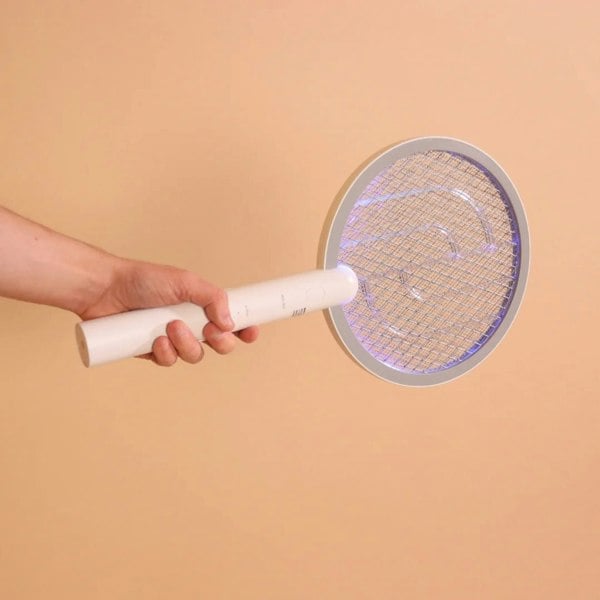 A hand holding the Senelux fly swatter, bug zapper