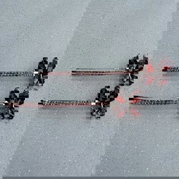 Gold hair slides, butterfly design, deep red crystal wings, long slim barrette style, rhinestone detailing along stem, sparkling decorative accessories, elegant vintage inspired look
