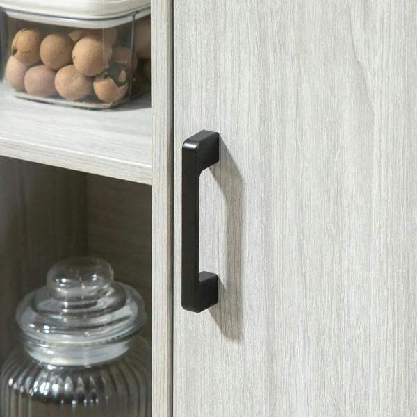 Light grey cabinet door handle with black pull on hinged storage door