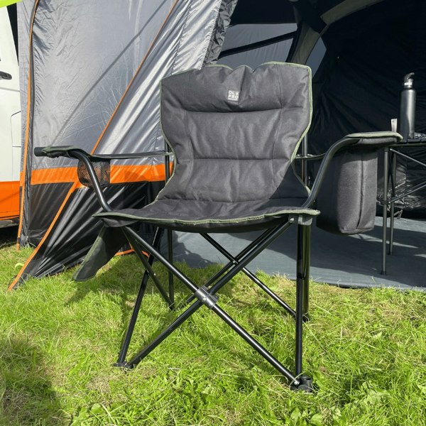 The Henwick Padded Folding Camp Chair - Black & Green from OLPRO outside of a campervan awning in a campsite.