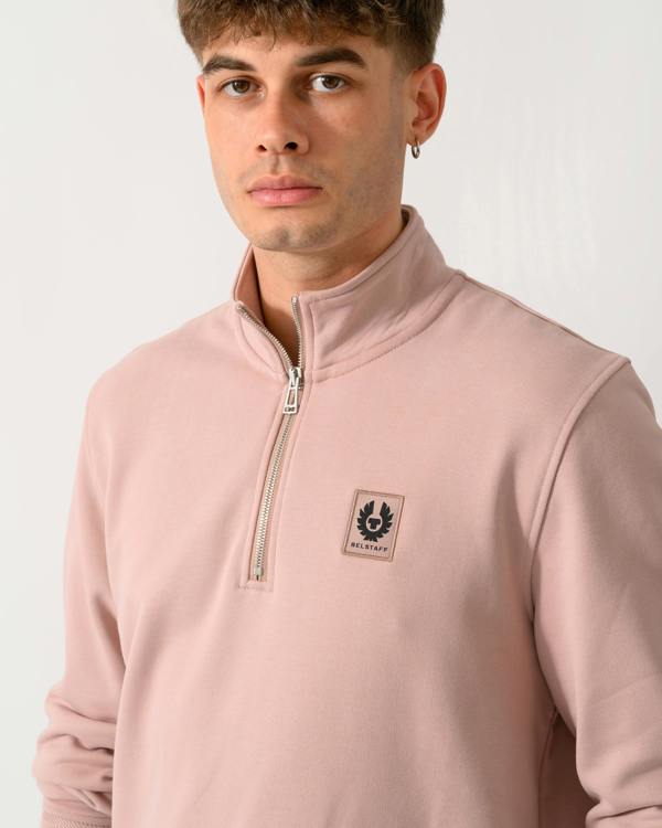 close up shot of a model wearing a Belstaff Mens Logo Quarter Zip Sweatshirt in Dusk Pink