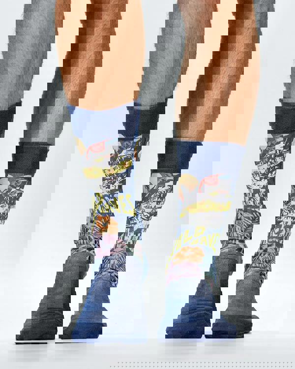 Colorful socks with shark design and 'WIld Waves' text worn by a person on a white background