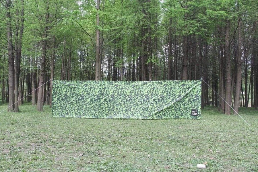 Laurel Hedge 4 Pole Compact Windbreak with Steel Poles by OLPRO pictured in a field.