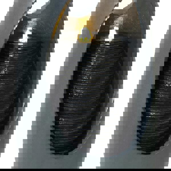 Sleek black electric water feature with a textured cylindrical fountain, softly illuminated by a warm glow, enhancing any space