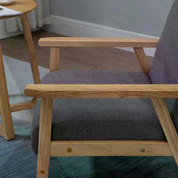 Grey upholstered accent chair with padded seat and light wood armrest details