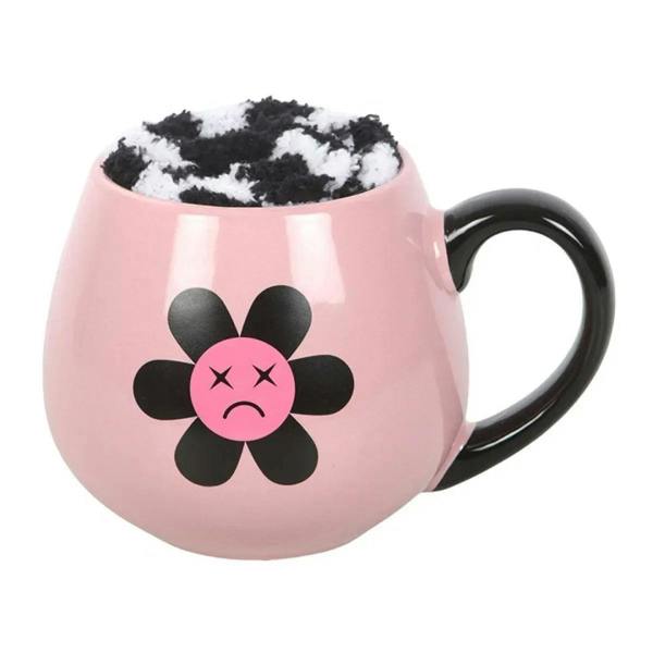 Pink ceramic mug with black handle, sad flower face graphic and shaggy rim filler