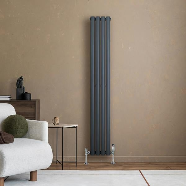 Anthracite grey oval single column radiator, 1600 x 240mm, mounted on a beige wall, complements modern interior decor with sleek design