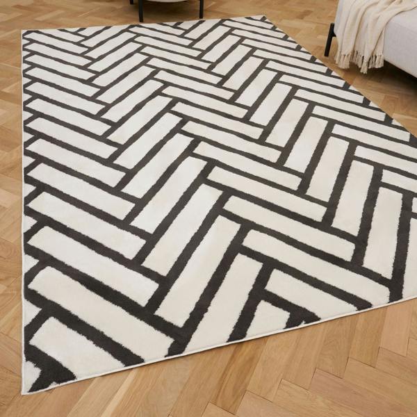 Black and white geometric patterned rug on a wooden floor