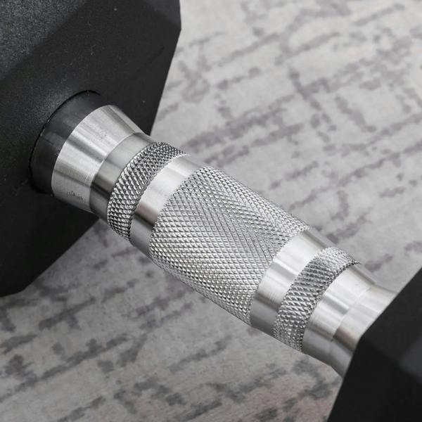 Knurled silver handle of black rubber hex dumbbell with textured grip details