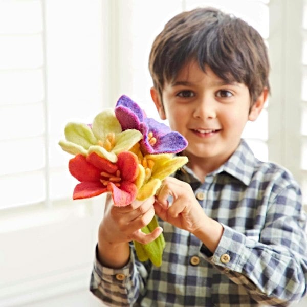 a young boy holding a Multicoloured Felt Flower Bouquet by Paper High.