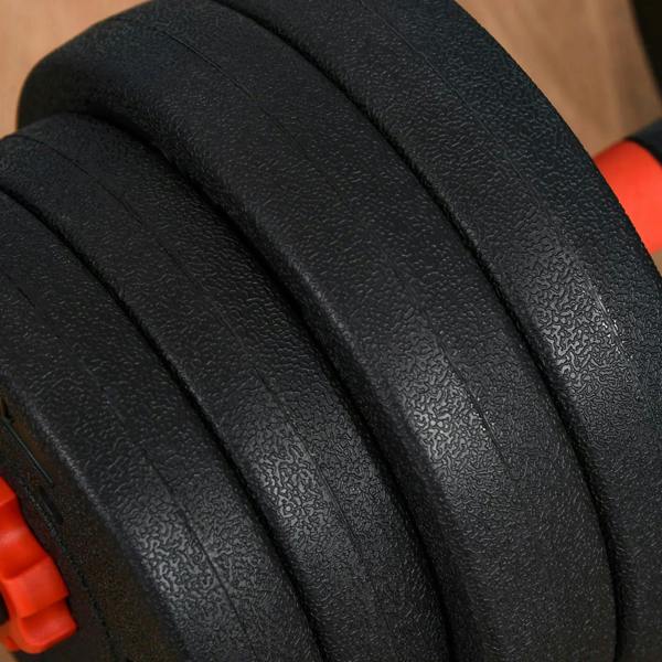 Close-up of black textured weight plates with red adjustment base on adjustable dumbbell set