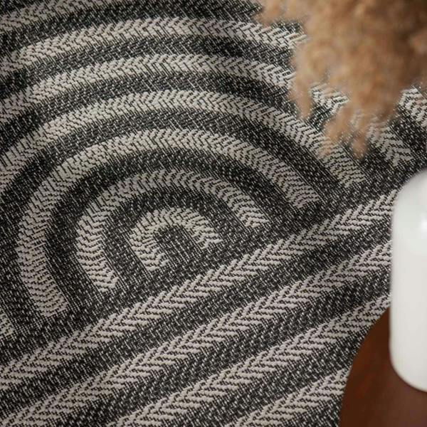 Close-up of a textured black and gray patterned fabric with a dog's paw partially visible.