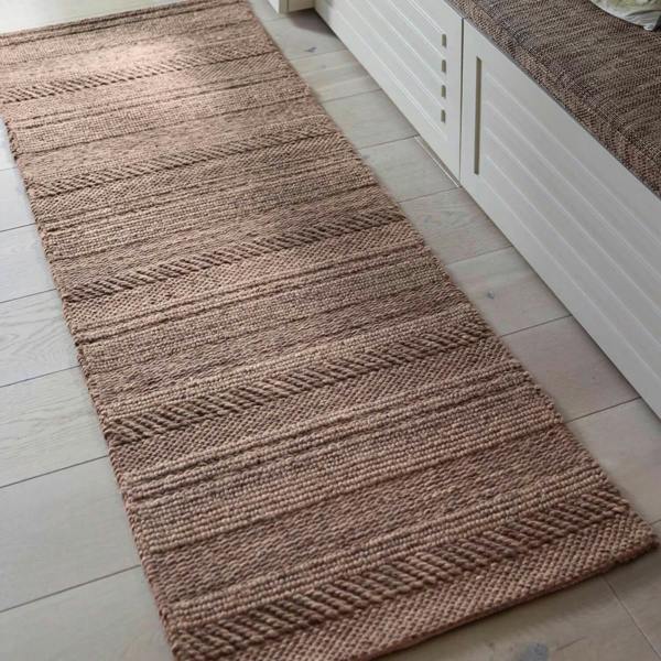 Brown textured rug on a light wooden floor