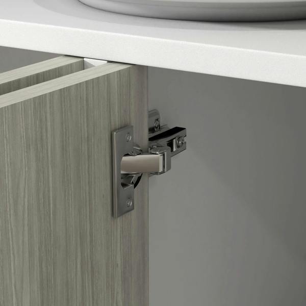 Close-up of sideboard door hinge and latch hardware on light wood panel