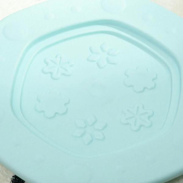 Close-up of light blue balance board inner panel with raised snowflake shapes