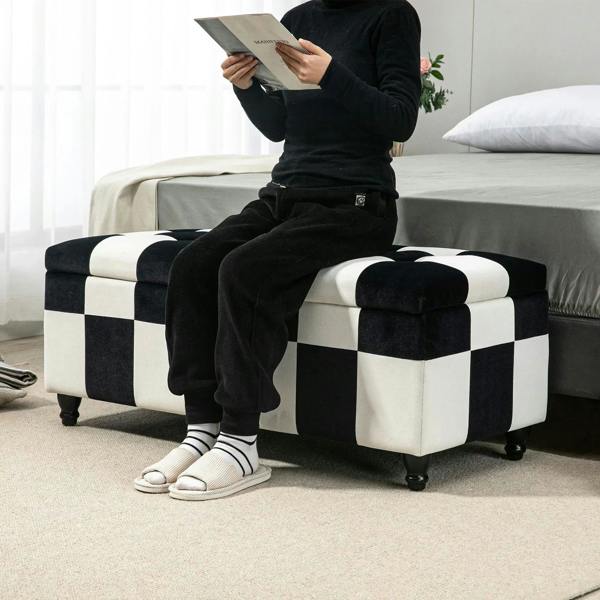 Black-and-white checkered velvet storage ottoman bench with hinged lid and wooden feet.