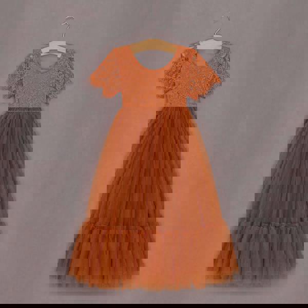 Orange lace dress on a hanger against a gray background