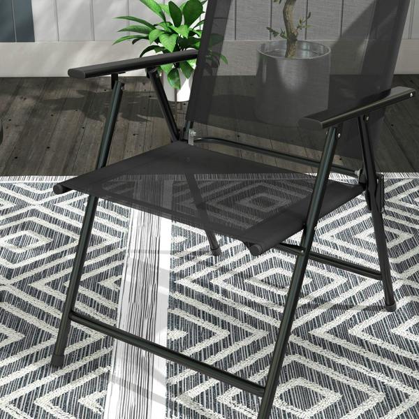 Black patio chair with mesh seat and armrests, glass-top table corner behind